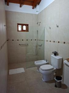 a bathroom with a toilet and a glass shower at Las Casuarinas in San José