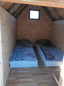 two beds in a room with a window at Eco katun Kofiljača in Plav