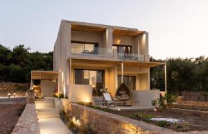 a house with a balcony with a chair in front of it at Enalis Studios & Apartments in Karfas