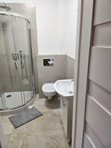 a bathroom with a shower and a toilet and a sink at Waldeslust Pension in Oelde +30 photos