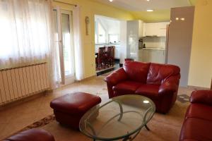 a living room with a red couch and a glass table at Apartments-Asquiro in Raskršće