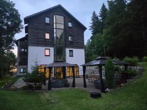 a large black and white building with a gazebo at Garden Depandance Am Bach in Kurort Altenberg