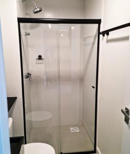 a glass shower in a bathroom with a toilet at Studio 705 Premium no Centro de Chapecó com Varanda Piscina Academia e Vaga Garagem AP Completo in Chapecó