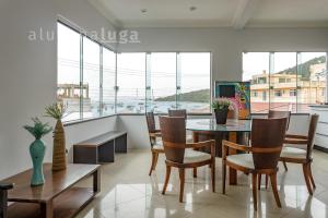 una sala da pranzo con tavolo, sedie e finestre di Casa ampla a 100m da praia – Conforto e lazer a Governador Celso Ramos