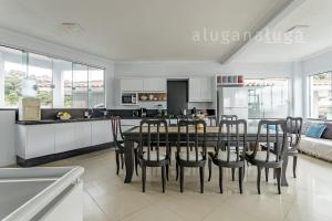 una cucina e una sala da pranzo con tavolo e sedie di Casa ampla a 100m da praia – Conforto e lazer a Governador Celso Ramos