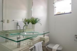 bagno con lavabo in vetro e specchio di Casa ampla a 100m da praia – Conforto e lazer a Governador Celso Ramos Altre 29 foto