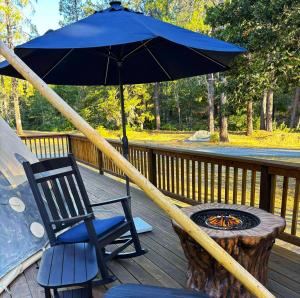 a blue umbrella on a deck with a chair and a table at The Grand in O'Brien