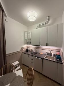 a kitchen with white cabinets and a sink and a table at Apartamenty Oakland in Debina +5 photos