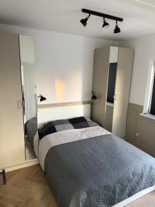 a bedroom with a large bed and a mirror at Apartamenty Oakland in Debina