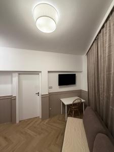 a living room with a couch and a table and a television at Apartamenty Oakland in Debina