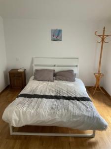 a bed in a bedroom with a cross on the wall at Bright house with garden in Saint-Sébastien-sur-Loire