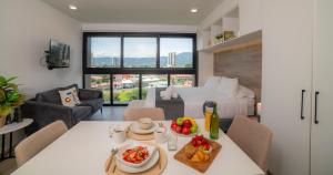 a living room with a table and a room with a bed at BEE Suites San José - Escalante in San José
