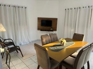 a dining room with a yellow table and chairs at Cantinho da val in Aparecida