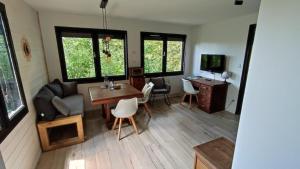 a living room with a table and a couch at Chalet Côtes de Meuse in Deuxnouds-aux-Bois