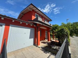 a red house with a white garage door at Beb ulivo in Santa Giuletta