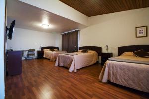 a hotel room with two beds and a wooden floor at Comfort Hostel in Guatemala