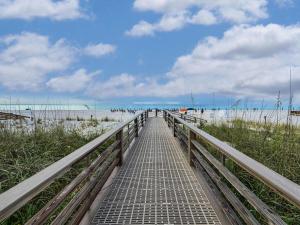 a walkway to the beach with the sand and the ocean at Sunset Crossing in Gulf Shores