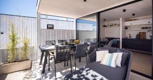 Una sala de estar con mesa de comedor y una cocina. en Villa Luna Mare Ferienhaus mit Terrasse & Poolnähe, direkt am Meer, en Privlaka