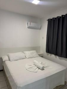 a bed with two white towels on top of it at Flat Pedra Branca Hotel in Palhoça +19 photos