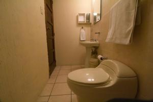 a small bathroom with a toilet and a sink at Comfort Hostel in Guatemala