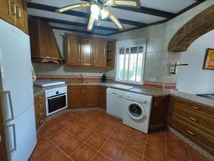 Una cocina con lavadora y ventilador de techo. en Finca La Serena - Badajoz, en Cabeza del Buey 19 fotos más