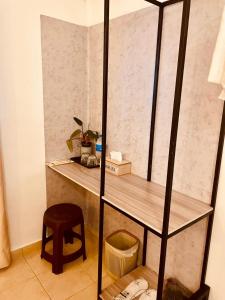 Un estante en una habitación con una silla y un taburete. en Bees Airport Hotel, en Katunayake