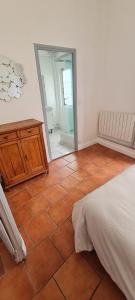 a bedroom with a bed and a mirror and a tiled floor at Le pied du château - Chinon centre in Chinon