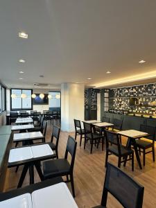 a restaurant with tables and chairs and a bar at Flat Pedra Branca Hotel in Palhoça
