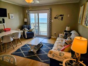 a living room with a couch and a table at Ocean Front Paradise 364 in North Topsail Beach