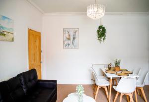 a living room with a table and white chairs at The Eastbourne Suite, 4 bedrooms,5 beds, FREE parking in Eastbourne