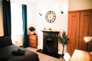 a living room with a clock on the wall and a bed at The Eastbourne Suite, FREE CAR PARK in Eastbourne