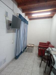 a room with a tv and a couch and a table at hospedaje la providencia cabaña in Comodoro Rivadavia