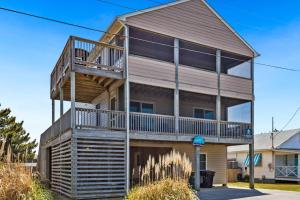 a house with a deck on the side of it at 5042 - Beachside Hangar in Kill Devil Hills