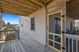 a front porch of a house with a wooden door at 5042 - Beachside Hangar in Kill Devil Hills