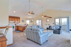 a living room with two couches and a kitchen at 5042 - Beachside Hangar in Kill Devil Hills