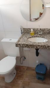 a bathroom with a toilet and a sink and a mirror at Chalé Rota dos Guarás in Santo Amaro