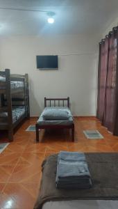 a room with two beds and a flat screen tv at Mãe Maria in Aparecida