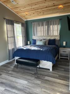 a bedroom with a bed with blue walls and a wooden ceiling at Private Cabin on 90 Acres! in Wright City