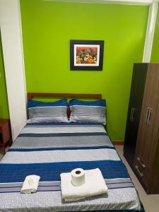 a bedroom with a bed with a green wall at JarAirbnb in Pucallpa