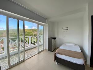 ein Schlafzimmer mit Bett und großen Fenstern in der Unterkunft Hostal San Andres Divers in Gustavo Rojas Pinilla International + 50 Fotos