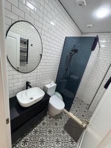 a bathroom with a sink toilet and a mirror at Kobuleti One in K'obulet'i +12 photos