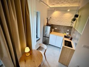 a small kitchen with a wooden table and a small kitchen with a counter at Apartamenty Młyńska 3A in Gliwice +28 photos