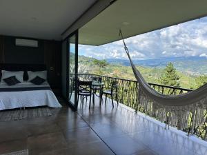 a bedroom with a bed and a balcony with a hammock at BALCÓN DE SANTA MARÍA 1 uno in Dosquebradas