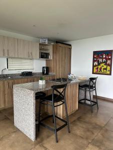 a kitchen with a counter and two bar stools at BALCÓN DE SANTA MARÍA 1 uno in Dosquebradas +28 photos