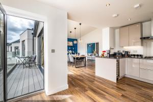 an open kitchen and living room with a balcony at Beach Haven in Perranporth