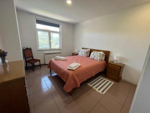 a bedroom with a bed with a orange bedspread and a window at Casa de Casarelhos - Estúdio Piso 0 ou AL Piso 1 - "Gerês" in Geres +138 photos