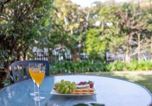 a table with a plate of food and a glass of orange juice at Kiama Beachscape on Manning in Kiama
