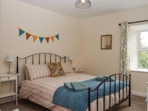 a bedroom with a bed and a window at Aunty Junes Cottage in Okehampton