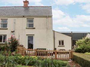 a house with a wooden fence in front of it at Aunty Junes Cottage in Okehampton