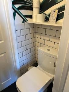 a bathroom with a toilet and a shelf with toilet paper at Cozy Croydon home with private garden & free parking contractors & family in Croydon +34 photos